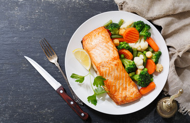 plate of baked salmon steak with vegetables