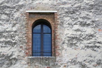 Window in Romanesque architectural style in medieval wall