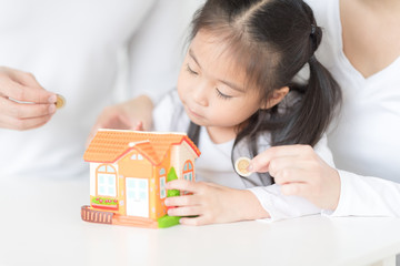 Parents are teaching daughter on saving money and financial planning.