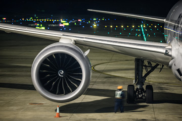 airplane at parking apron view from window of waiting hall of air terminal at night
