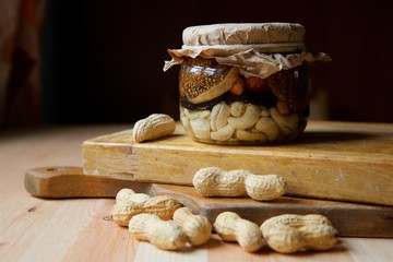 Jam of different types of nuts and fruits in syrup or honey in a glass jar