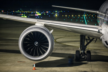 airplane at parking apron view from window of waiting hall of air terminal at night