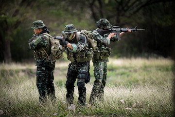 Squad of soldiers patrolling across the forest area.