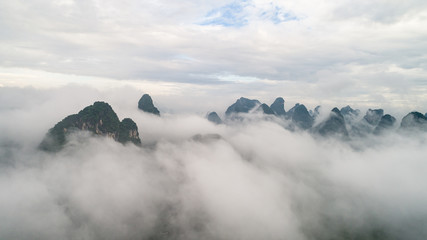 aerial view of cloudscape above farmland, river and roll of hills
