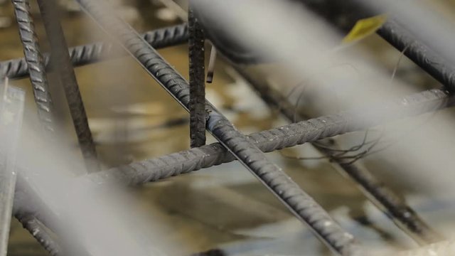 Industry construction worker is welding steel reinforcement on a modern construction site using electric welding machine