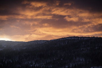 Snowy landscape in sunset with red burning sky