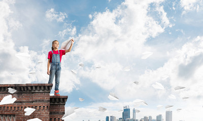 Concept of careless happy childhood with girl dreaming to become pilot