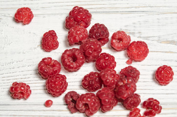 Ripe sweet raspberries on a wooden table.