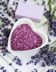 Fototapeta na wymiar Heart-shaped bowl with sea salt, soap and fresh lavender flowers