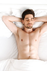 Fototapeta na wymiar Naked man sleeping in bed indoors at home.