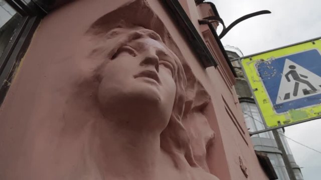 Sculpture of the woman face on the wall of an old house in St. Petersburg