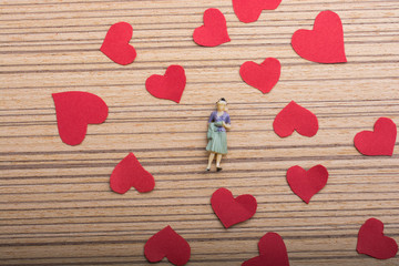 Woman figurine and Love concept with paper hearts