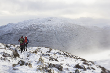 Naklejka premium Winter climbers on a snow covered mountain in Scotland
