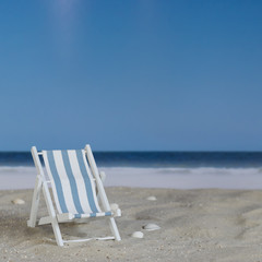Blue white striped deck chair on the beach, square