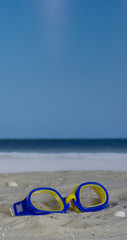 Swim goggles in the sand on the beach
