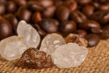 Coffee beans and cinnamon on a background of burlap. Roasted coffee beans background close up....