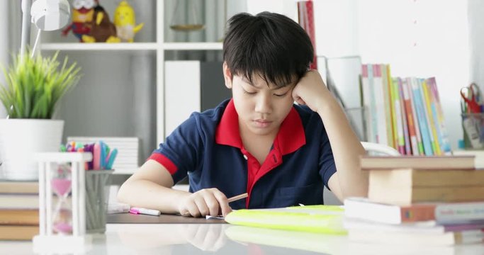 Asian preteens doing your homework with tablet computer with serious face.