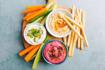 Fresh vegetarian dips in small bowls on table