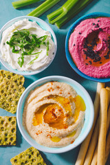 Fresh vegetarian dips in small bowls on table