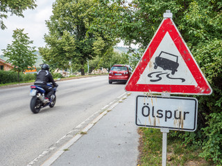 Warnschild mit Ölspur