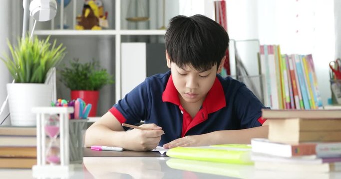 Asian preteens doing your homework with tablet computer with serious face.