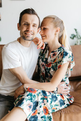 Photo of couple in love sitting on leather sofa
