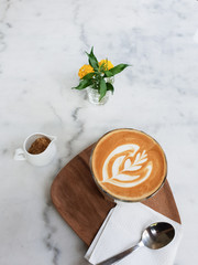 Hot coffee latte art  in cup on white marble background.