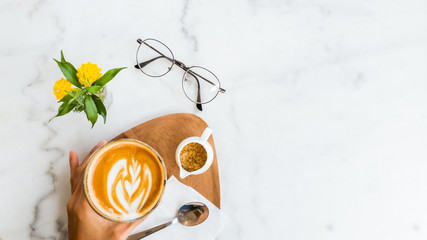 Hot coffee latte art  in cup on white marble background.