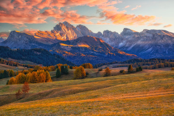 Fototapeta premium Amazing autumn scenery of Alpe di Siusi at sunrise. Majestic mountains and colorful sky in background, Dolomites, Italy