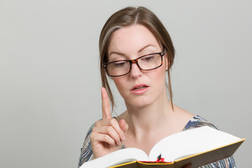 Junge Frau hat etwas Interessantes in einem Buch gefunden