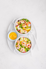 Salad with prawns in bowls on table