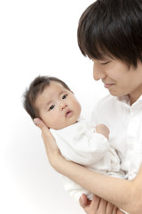 父に抱かれ見つめられる新生児の女の子