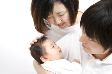 新生児を抱き見つめる若い夫婦、幸せな家族イメージ