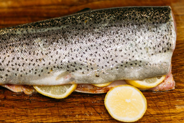 raw fish. raw fresh salmon, trout, on a table on a cutting board. with lemon ready for baking