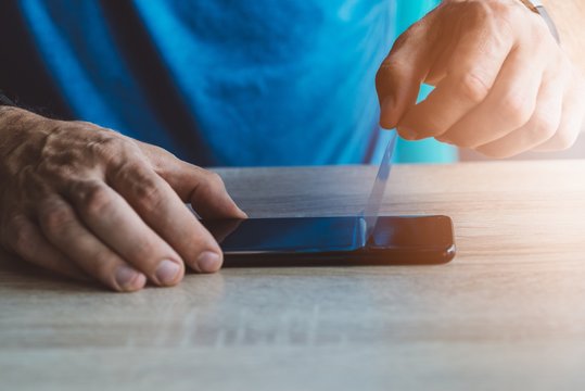 Man applying protective screen protector