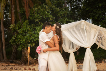 Beautiful married couple is celebrating their wedding on the beach