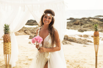Fototapeta na wymiar Happy smiling bride in beautiful wedding dress on the beach