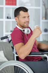 disabled business man in wheelchair is drinking coffee