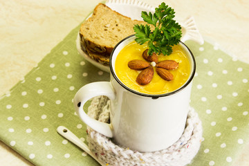 Cream of pumpkin soup with parsley and almonds. A traditional autumn dish. Top view.
