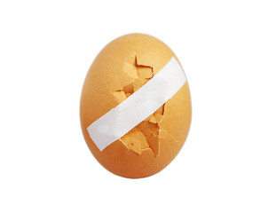 Cracked egg for breakfast is glued with a band-aid. Cracked breakfast egg.