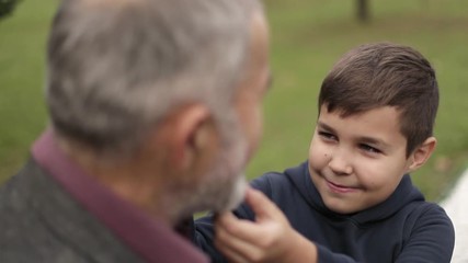 Grandson touches the beautiful beard of his grandfather