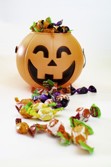 Halloween pumpkin with candies by the side, with white background.