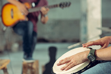 Repetition of rock music band. Electric guitar player and drummer behind the drum set.