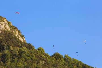 .Paragliders train on the lake Serre-Poncon. France.