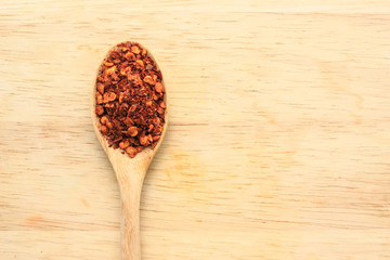 cayenne pepper spoon on wooden background