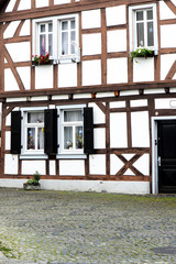 old small German town on the river bank narrow streets, pavement flowers on the windows