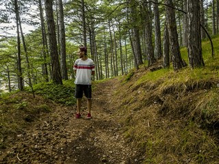 young man in casual walking in the forest lonely alone during summer season