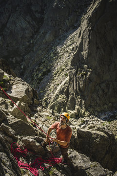 Portrait of a climber on belay wearing helmet taking care of the climber