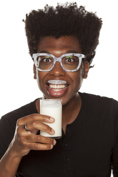 Portrait of young african american man drinking yogurt from a glass  on white background