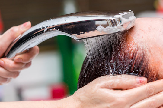 Hairdresser washing client hair. Closeup view.